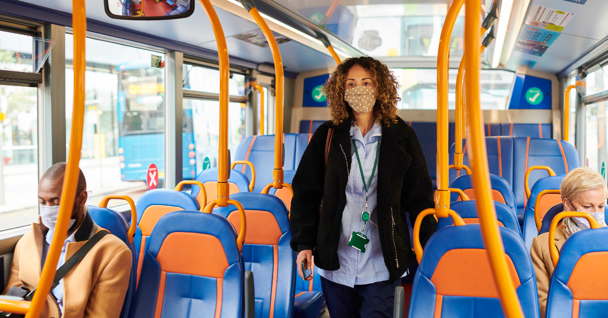 Mask Transit: A nurse, wearing her mask, maintains physical distance on transit.