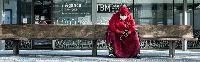 Mask Transit: Woman waits for a tram in Bordeaux, France. Photo by Chapman Chow on Unsplash.
